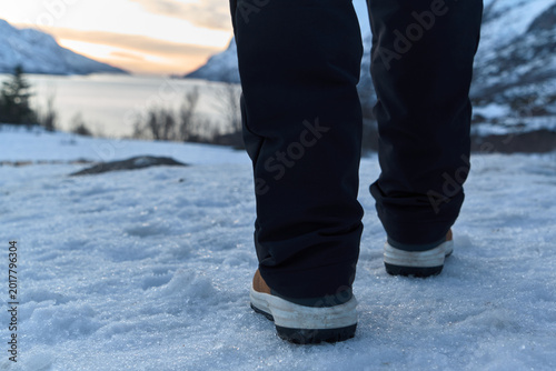 Walking on Snow-Covered Ground in Norway During Sunset
