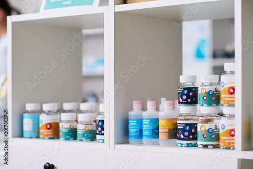 Cuadro en lienzo Close up of vitamin supplements and antiseptic gel bottles standing on pharmacy shelf, presenting healthcare retail and wellness products