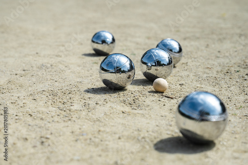 Cuadro en lienzo Steel petanque balls in mix of sunlight and shade on gravel court, chrome reflec