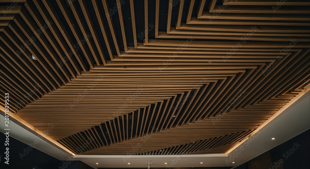 Fototapeta premium Modern wooden slat ceiling with geometric pattern and warm accent lighting, interior design inspiration with copy space