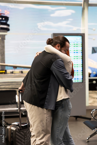 Photography Boyfriend and girlfriend reuniting in airport terminal with joyful emotions, hugging and smiling after arrival