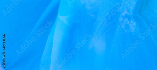 Soft vibrant blue translucent fabric texture with flowing folds, dreamy lighting, airy textile layers, smooth pastel tones, and elegant abstract background.