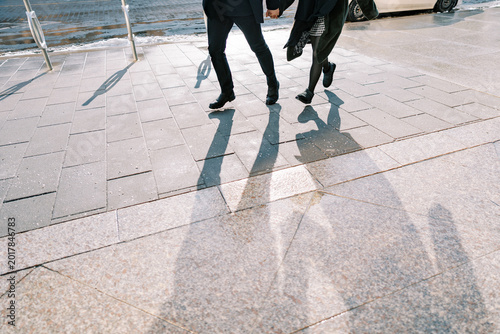 Foto Individuals in business attire move quickly by river