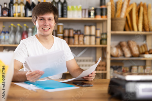Принти на полотні Store manager draws up documents for the purchase of food and groceries for the supermarket