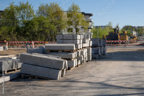 Foto Construction site filled with pallets of granite curbs, used for road constructi