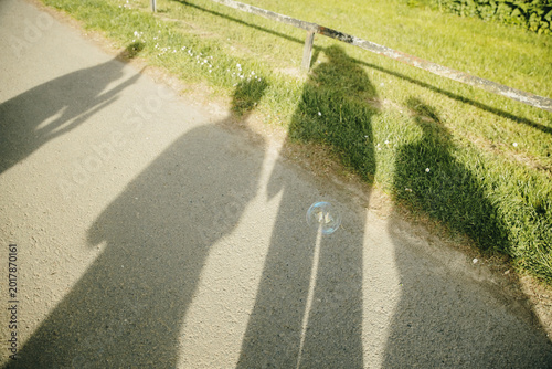 Foto One soap bubble and four shadows of people in the park.