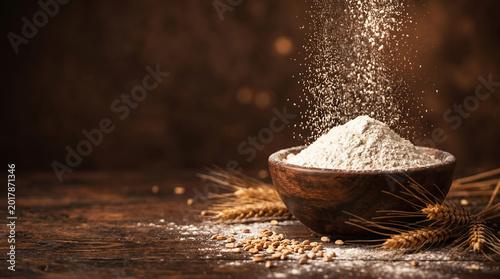 Sifting wheat flour into wooden bowl with wheat ears and grains on rustic table