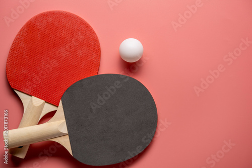 Ping pong rackets and balls on pink background, flat lay