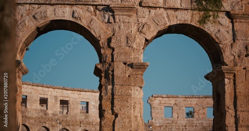 View of stone arches and columns inside the ancient Pula Arena Roman amphitheater in Pula Croatia.