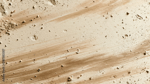 Top view of dry sandy ground texture with visible soil patterns and earthy tones