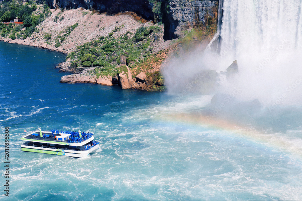 Fototapeta premium Tour boat approaching misty Niagara Falls rainbow