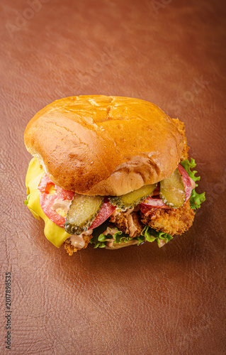 Small burger with vegetables on wooden table