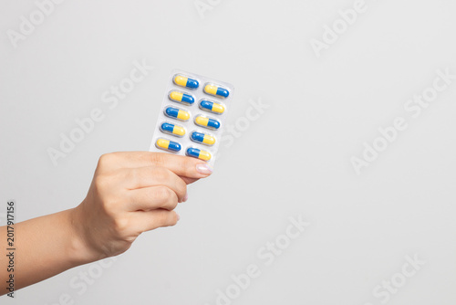 Konstfotografi Hand holding blister pack of blue yellow capsules