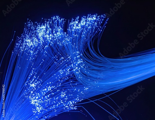 Blue fiber optic strands glowing on black, abstract light trails, technology network, digital connectivity