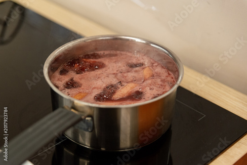 Fényképezés Fruit and berry compote boiling in stainless pot on stove for cooking and health