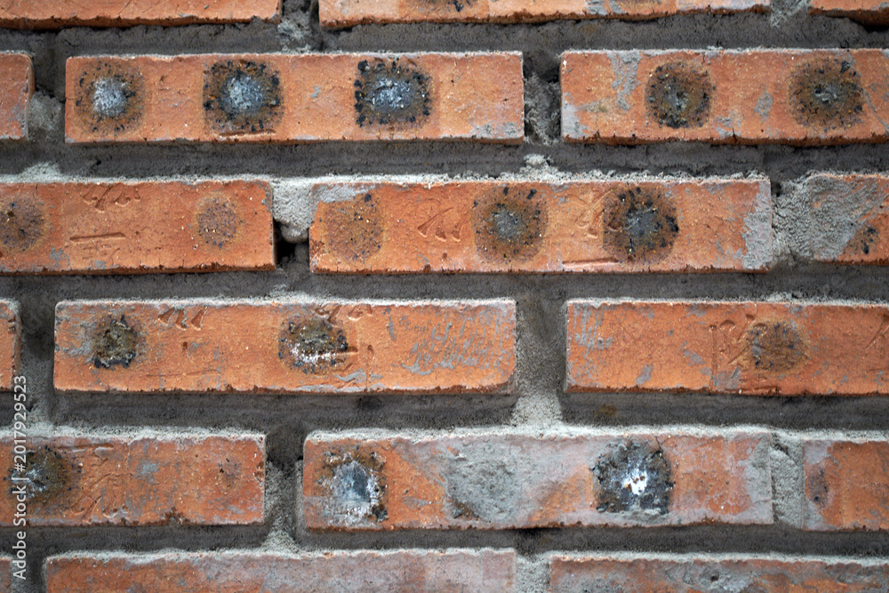 Fototapeta premium Close up view of aged weathered red brick wall texture