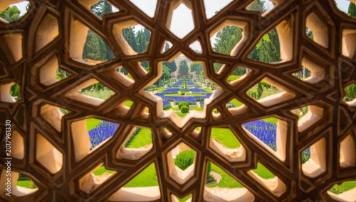 Intricate Geometric Window Overlooking a Lush Garden with Purple Flowers