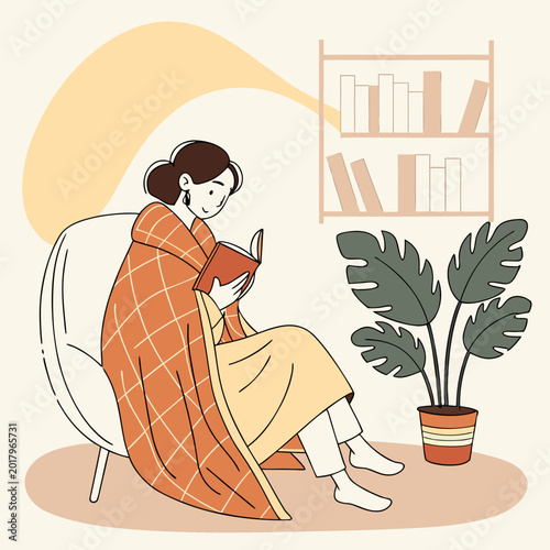 Obraz na plátně Woman reading a book wrapped in a blanket near a plant on a cozy day indoors