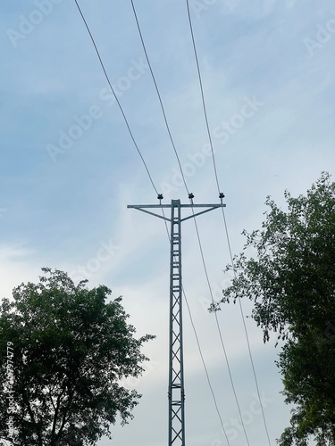 High voltage power lines and transmission tower under a blue sky or nature