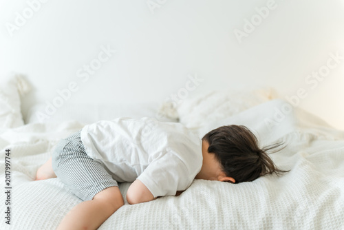 Cuadro en lienzo A boy lying on a bed, playing around.