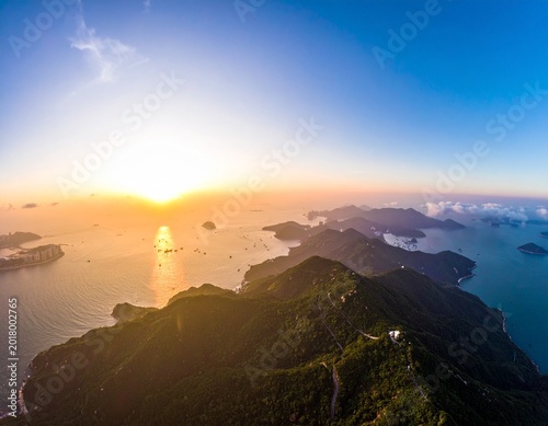 sunset over island mountain ridge aerial view ocean ships horizon golden hour