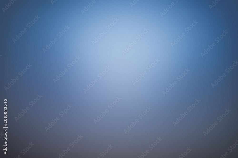 Obraz premium Professional blue gradient background with soft central light. Smooth texture and elegant vignette, ideal for corporate presentations, studio portraits, and modern digital wallpapers.