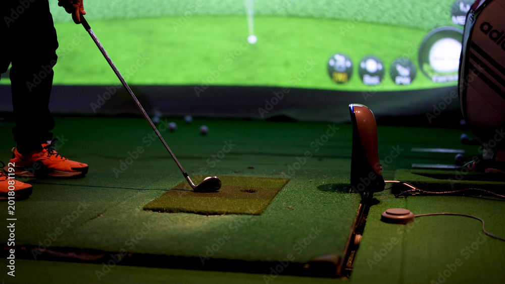 Fototapeta premium Close Up of Golfer Preparing to Hit Ball in Indoor Simulator