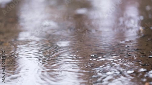 Raindrops falling on the ground. Slow motion