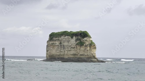 Remote Sea Stack Island with Green Top in Overcast Ocean Landscape
