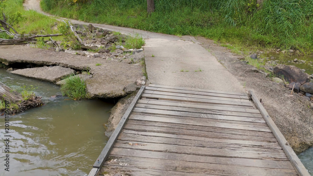 Obraz premium Small Wooden Bridge and Concrete Path Over Tweed River in Uki