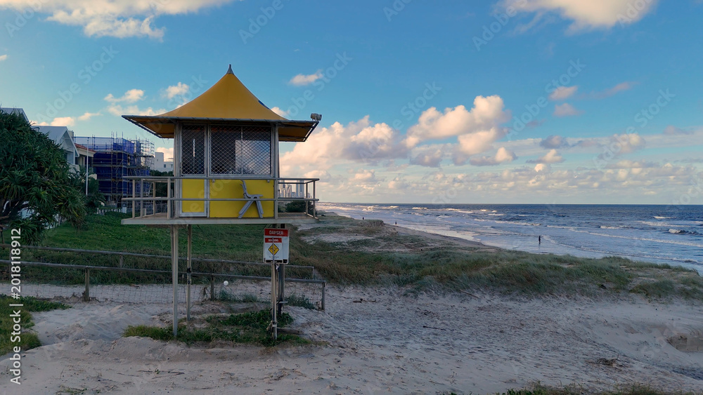 Fototapeta premium Yellow Lifeguard Tower Overlooking the Ocean on a Sunny Day