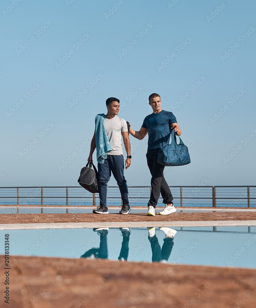 Naklejka premium Men, friends and swimmer with gym bag for outdoor practice, sport or preparation together. Active, male people or athletes ready with equipment at swimming pool for fitness, competition or training