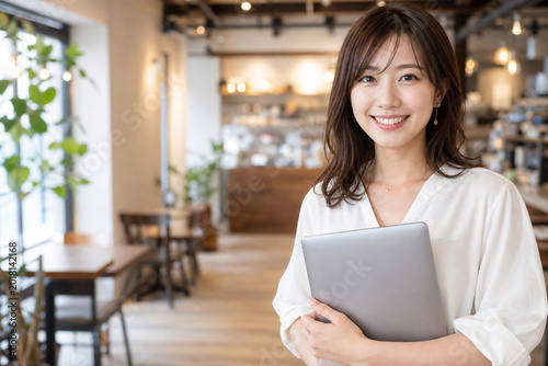 Fototapeta カフェでPCを持つ笑顔の日本人女性