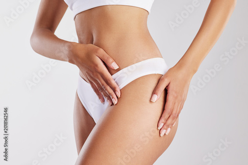 Fotografie Skincare, hips and hands of woman in studio for liposuction, cellulite treatment and lose weight