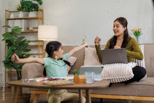 Billede på lærred Mother and daughter balancing remote work and childhood playtime