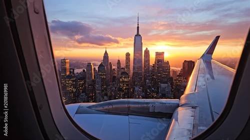 Aerial view of a city skyline at sunset, seen through an airplane window