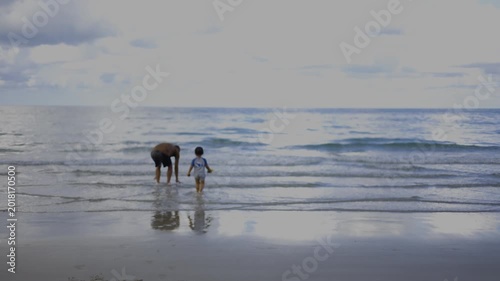 Father And Child Walking Into The Sea During Sunset 01