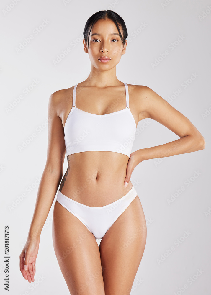 Naklejka premium Serious, portrait and woman with healthy body in studio, beauty and skincare with natural cosmetics. White background, confident and person in underwear, lose weight and wellness goals in Brazil
