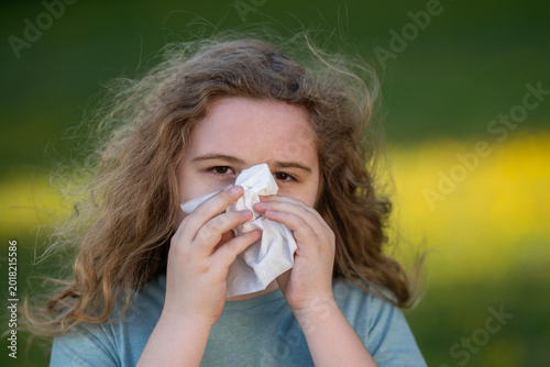 Φωτογραφία Sneezing child uses white tissue