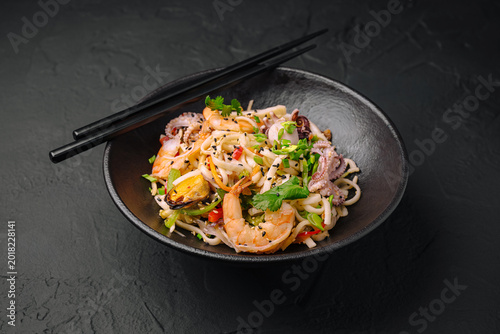 Shrimp and noodle dish with herbs and vegetables served in a bowl