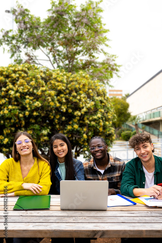 University students studying together outdoors with laptop