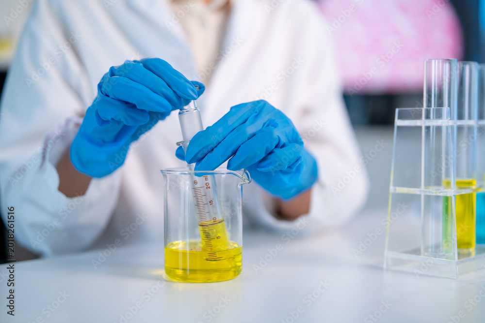 Fototapeta premium Close up of female scientist in white lab coat working in the laboratory