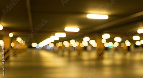 Abstract defocused background of a brightly lit underground parking garage with warm bokeh lights.