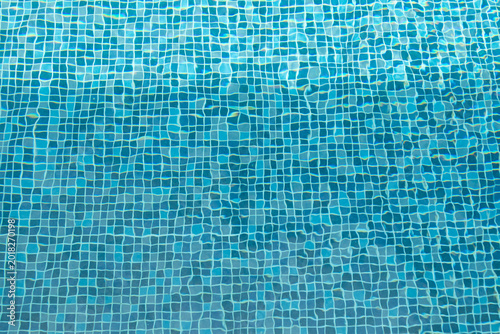 Foto Swimming pool water surface and ripple wave with blue mosaic tiles