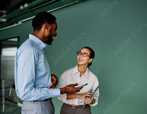 Portrait of young businesswoman and businessman using a tablet having a meeting or presentation and seminar in the office