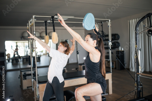 Quadro su tela Women exercising during pilates class, strengthening core and body