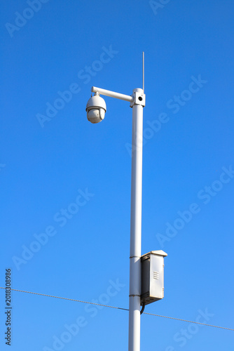 Photography High-speed dome PTZ camera on a pole against a clear blue sky