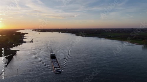 River shipping at sunset on a wide waterway in Europe