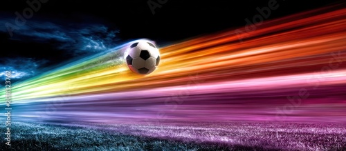 Soccer ball flying through colorful streaks.
