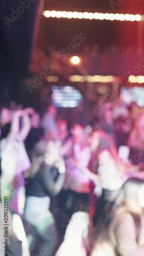 Crowd engaged in lively singing. Energetic congregation under colorful stage illumination and motion